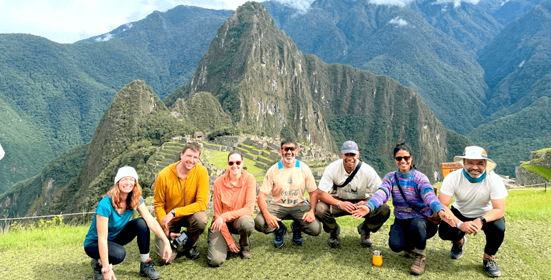 Ancient Inca trail through misty Andean mountains with stone pathways and lush green vegetation leading to Machu Picchu ruins in the distance