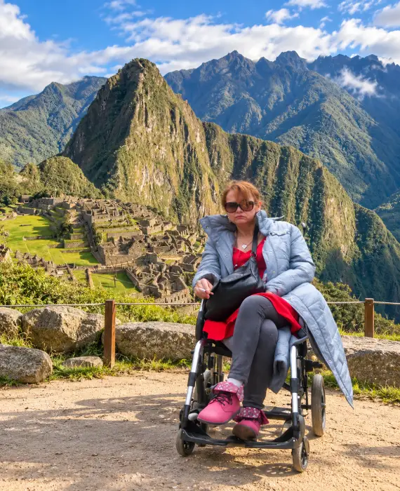 Traveler in a wheelchair in front of the citadel of Machu Picchu, Cusco