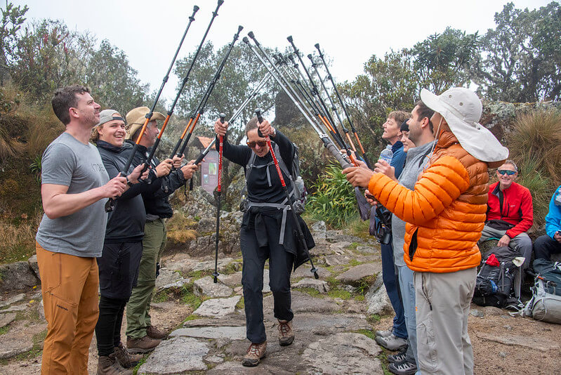 Salkantay mountain trek showing snow-capped Salkantay peak, turquoise glacial lakes, and rugged high-altitude terrain with trekkers in the distance under blue skies
