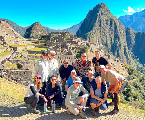 Group of happy trekkers reaching Machu Picchu summit