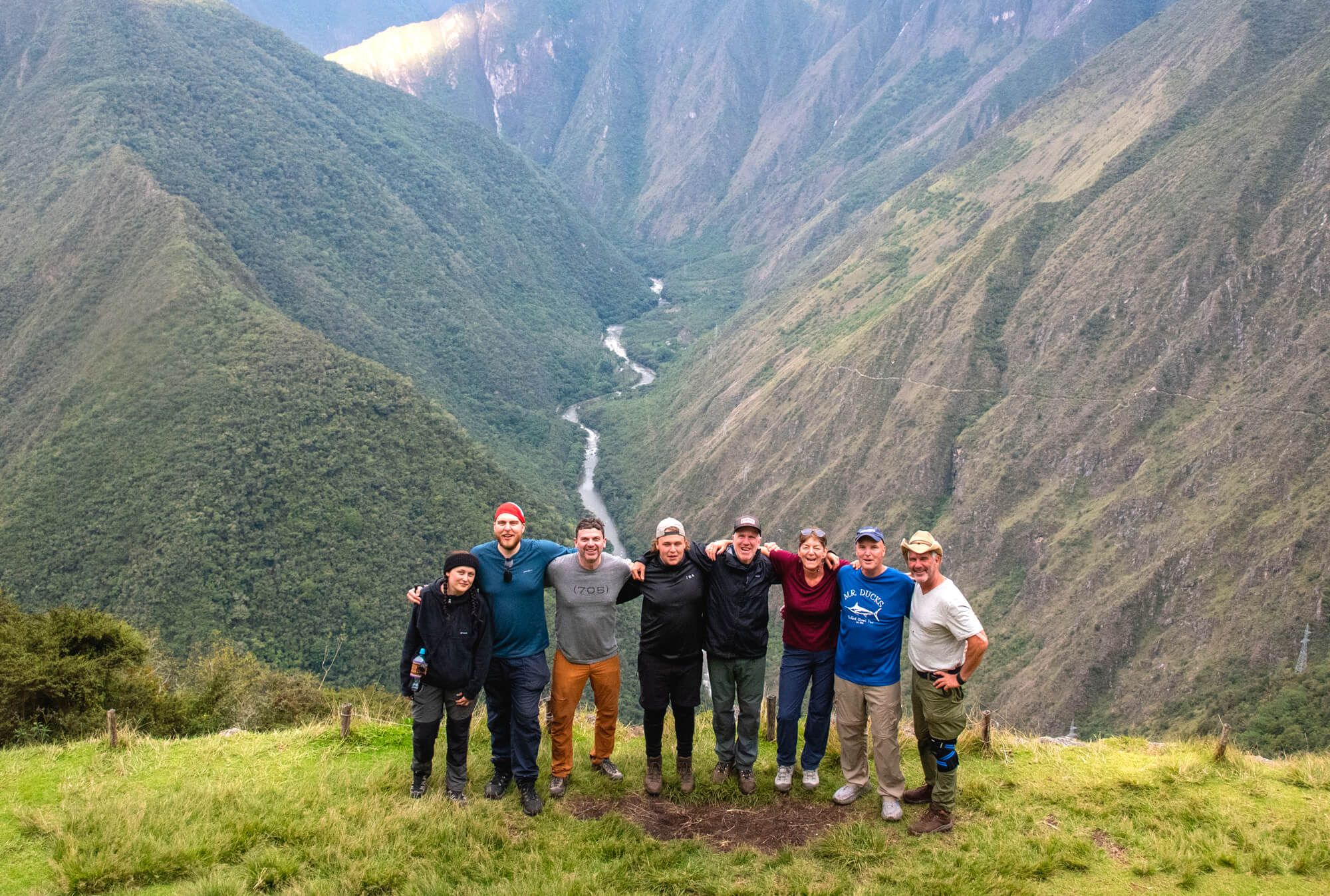 Breathtaking panoramic view of Machu Picchu citadel at sunrise with dramatic Andean mountain peaks, ancient terraced stone structures, and golden morning light illuminating the misty valleys below