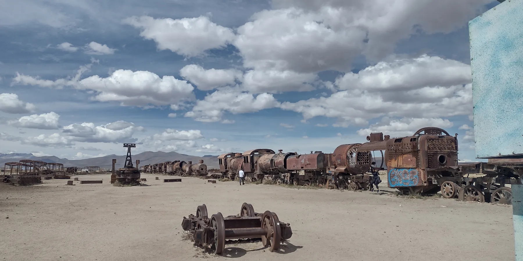 Cementerio de Trenes Uyuni Bolivia locomotoras oxidadas vagones abandonados desierto cielo nublado.