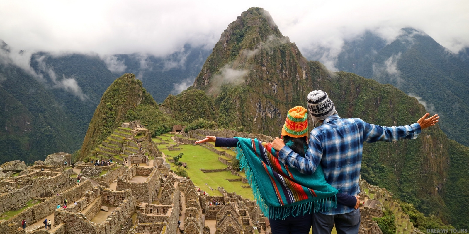 Group of smiling travelers with their guide in Machu Picchu, enjoying the panoramic view of the Inca citadel.