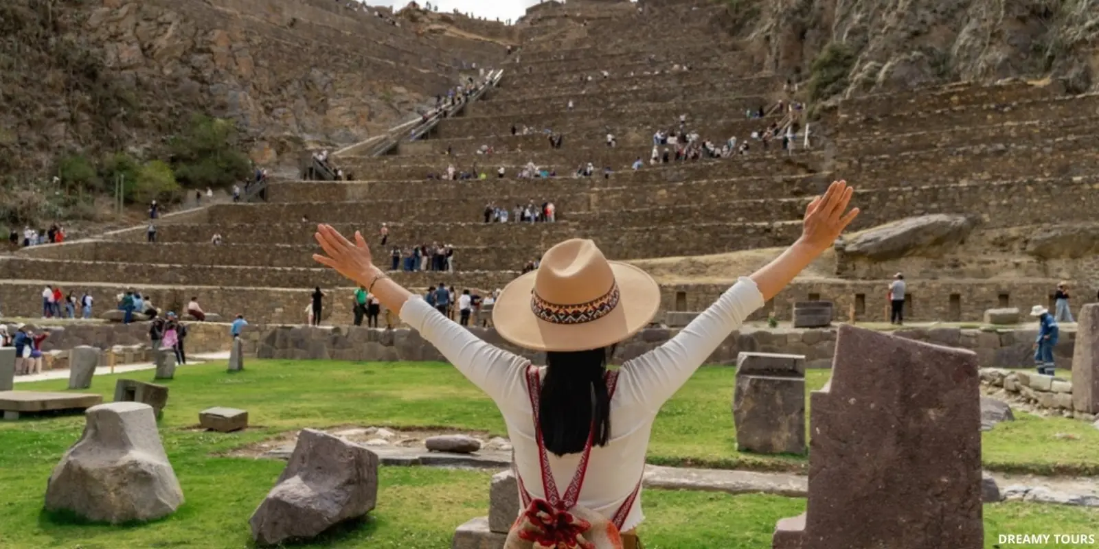 Ruinas incas de Ollantaytambo con terrazas agrícolas y montañas nubladas.